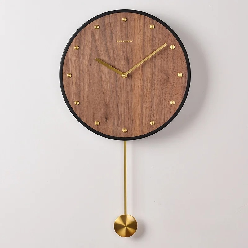 Horloge murale en bois avec contour noir, aiguilles dorées et balancier décoratif