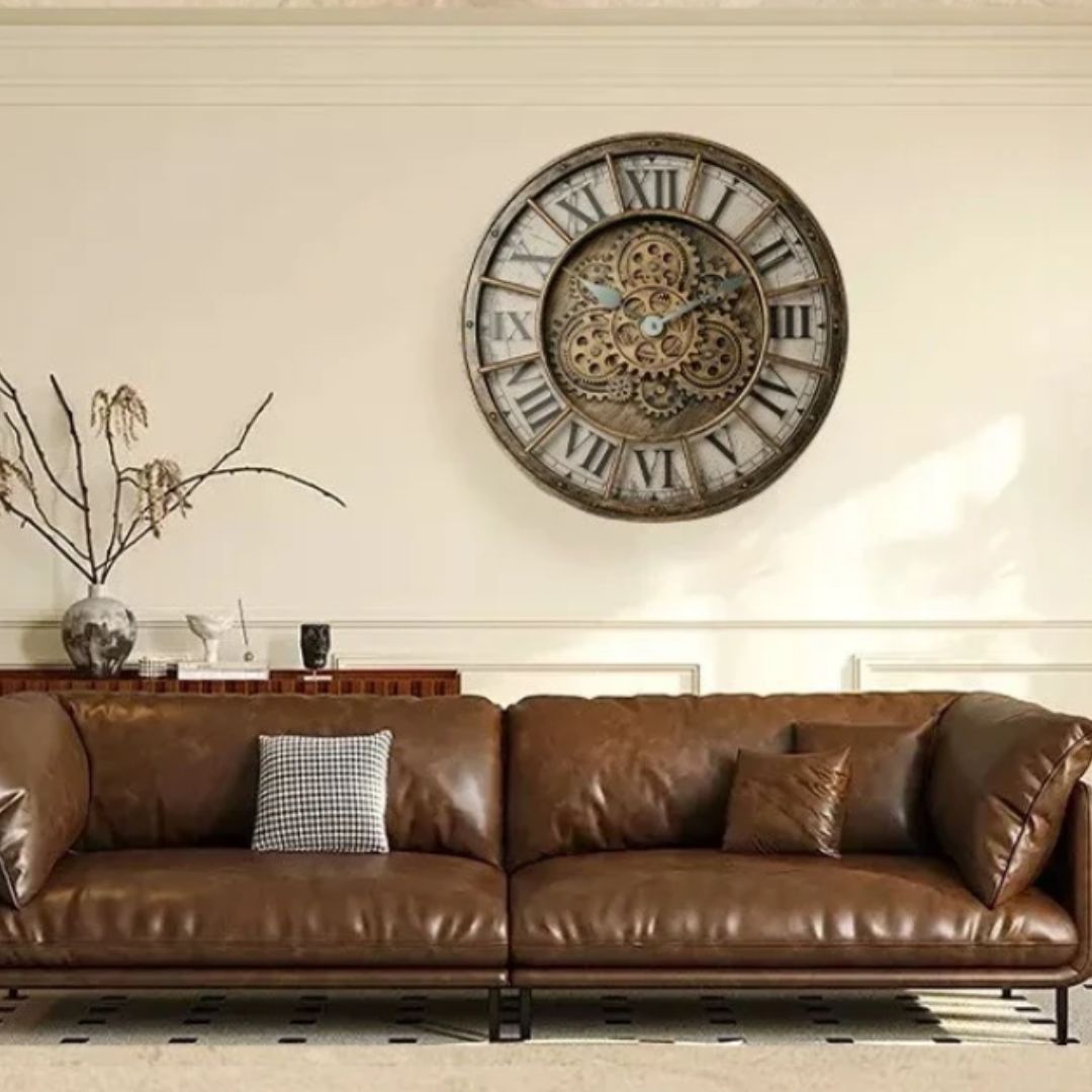 Horloge murale à engrenages bronze au-dessus d’un canapé brun